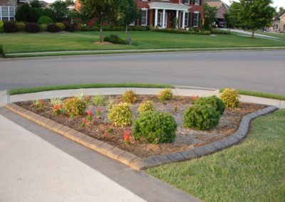 A flower bed in the middle of a driveway.