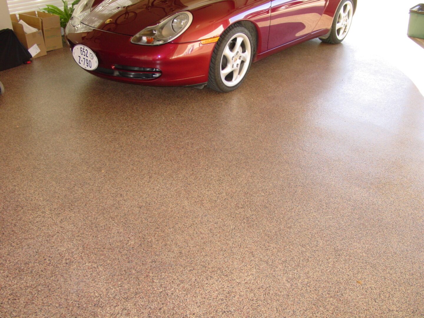 A red car parked in the middle of a garage.