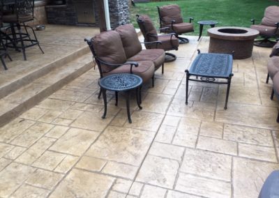 A patio with fire pit and chairs in it