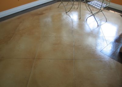 A floor with brown and tan colored concrete.