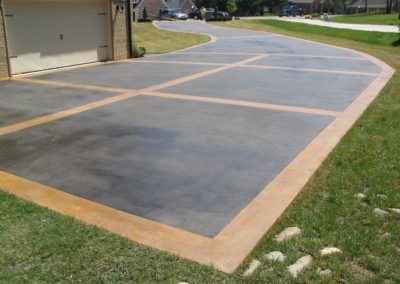 A driveway with concrete and grass in the middle.