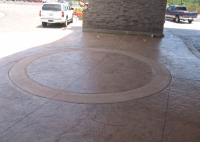 A car parked in front of a building with a circular pattern on the floor.