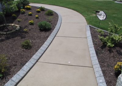 A walkway with concrete and stone border around it.