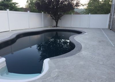 A pool that is in the middle of some concrete.