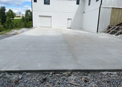 A concrete driveway in front of a house.