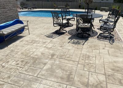 A concrete patio with a table and chairs.