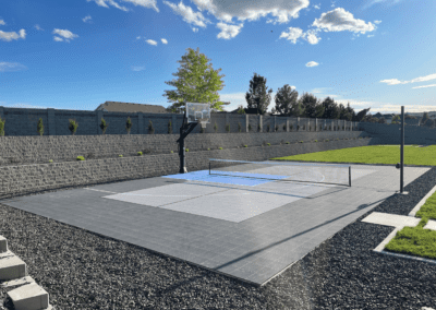 A backyard basketball court with a basketball hoop.